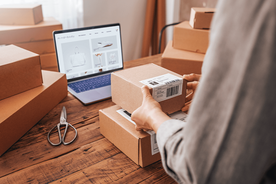 A business owner packages up some product ordered via online payment gateway.