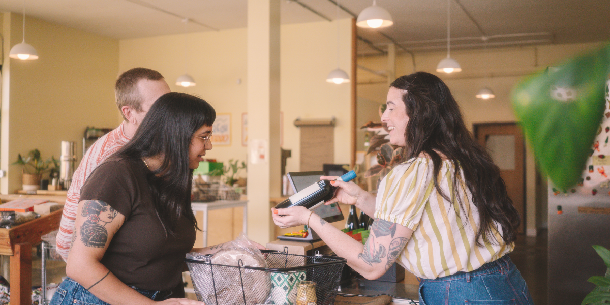 A customer uses a payment terminal at the checkout counter of a retail store.