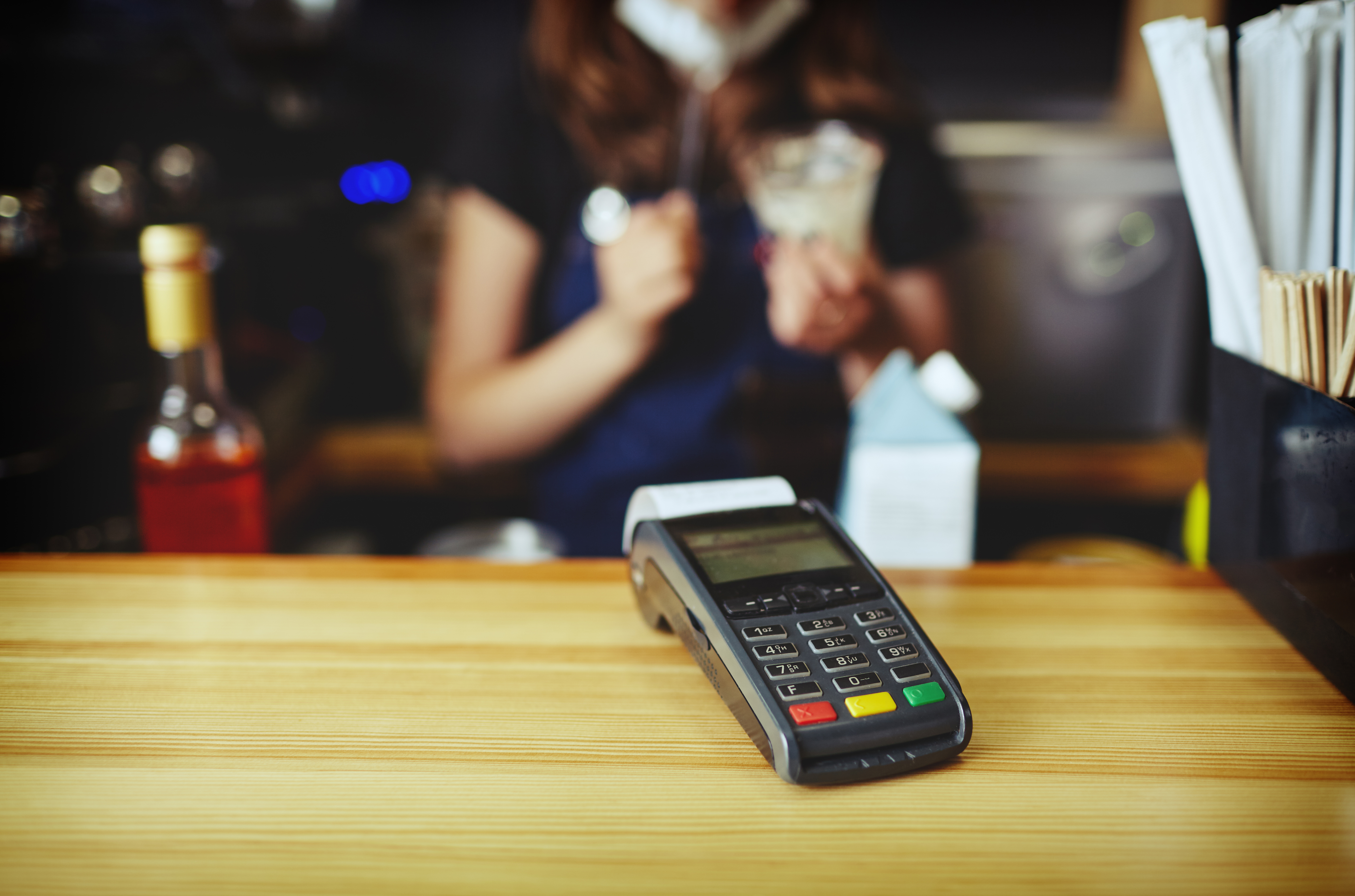 Paiement sans contact effectué avec une carte de débit à l’aide d’un terminal de paiement dans une petite entreprise.