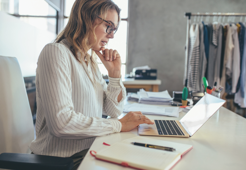 Personne travaillant sur un ordinateur portable à un bureau dans un espace de travail du commerce de détail.