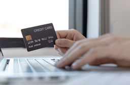 A person holding a credit card and phone