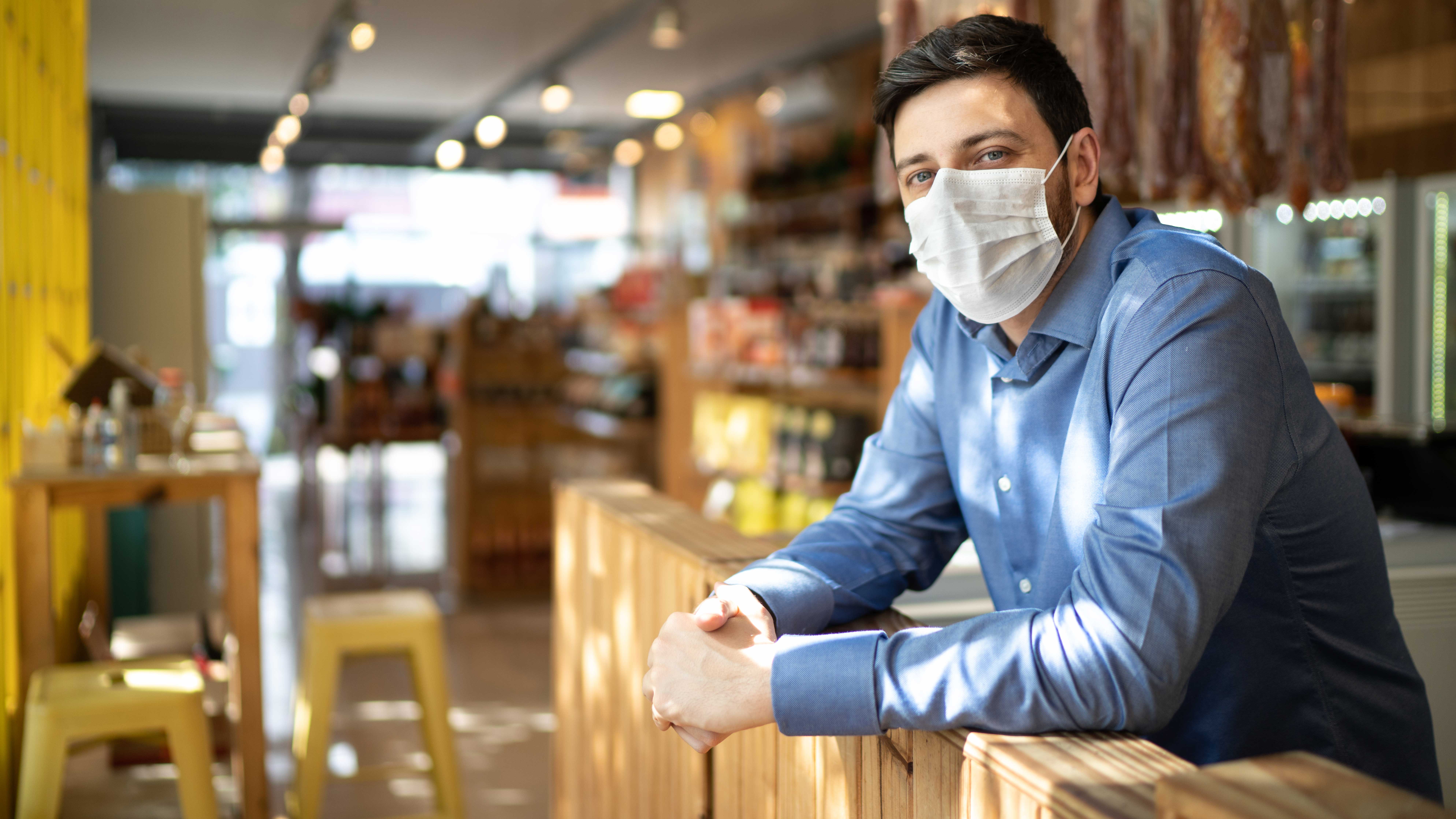 Man with mask leaning against something