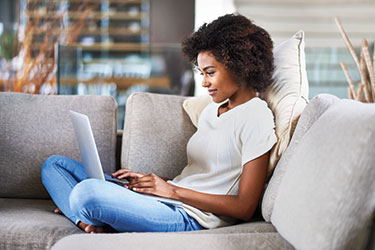 sitting on couch with laptop on lap