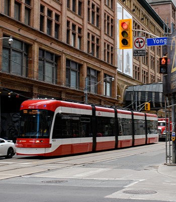 TTC red streetcar travelling through downtown Toronto, Ontario.
