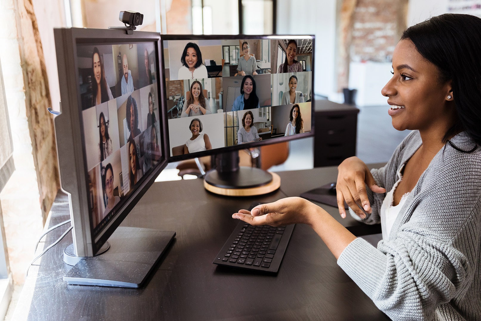 am employee leads a team meeting on dual monitors