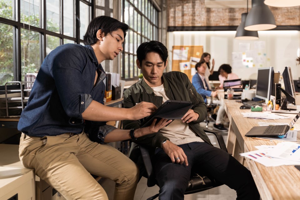 Two young Asian entrepreneurs look at a tablet considering the Start@Moneris program