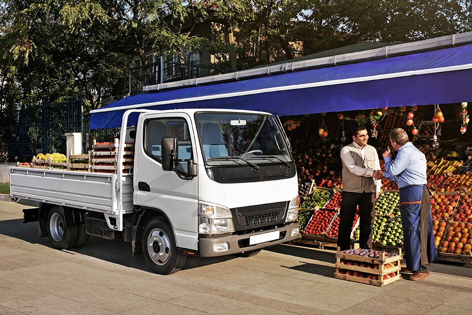 Buyer Initiated Payments hero image showing someone purchasing produce from a stand at a farmer's market