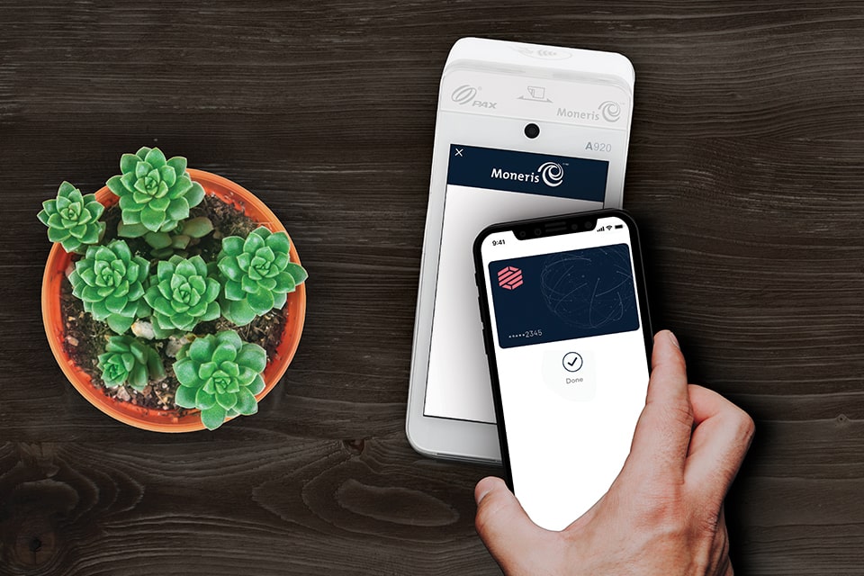 Apple Pay Banner Image showing a closeup of someone making a contactless payment using their mobile device on a Moneris Go terminal