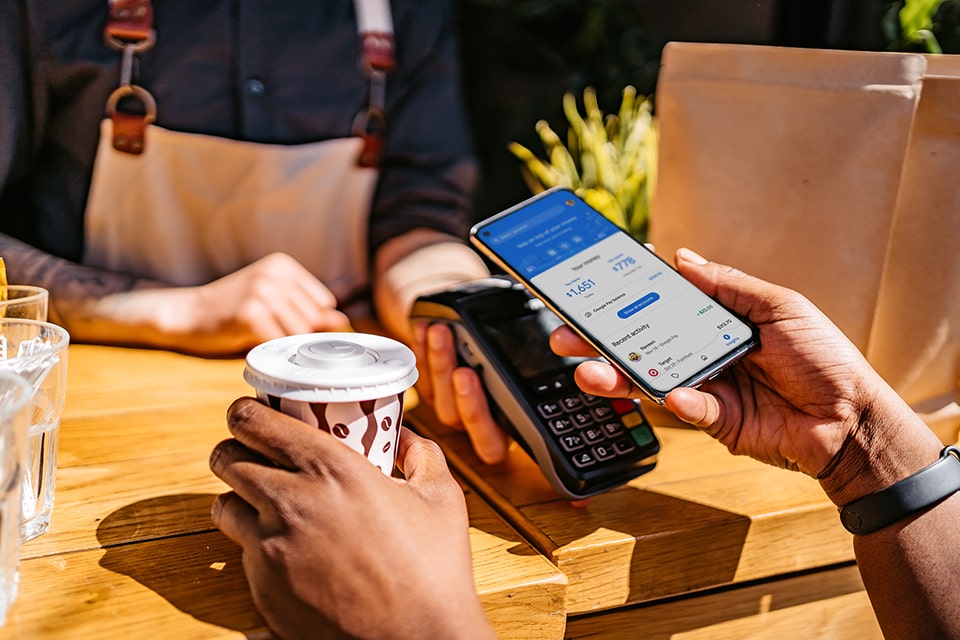 A closeup of someone making a contactless payment using their android mobile device on a Moneris Core terminal