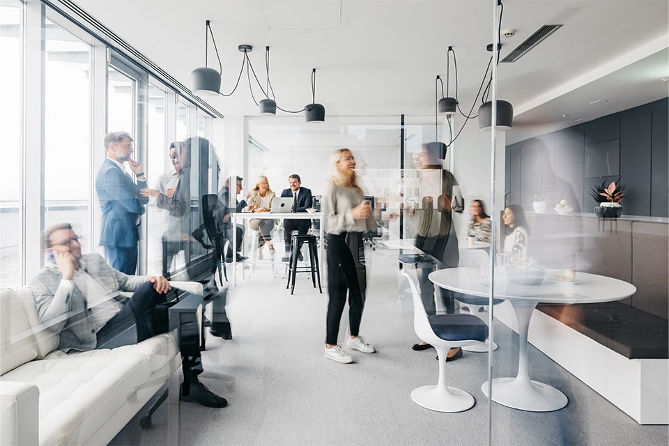 Careers related image with superimposed business people sitting and socializing in various spots in a modern office setting.